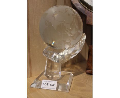 A glass globe mounted on a glass stand in the form of a hand