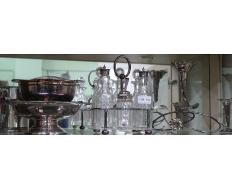 An Elkington plated six bottle condiment stand, a silver plated epergne, a plated rose bowl, etc.