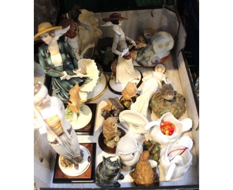 A box containing a collection of ceramic figurines, includes elegant figures and animals