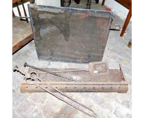 A cast iron fire fender, fire tools and a wrought iron spark guard.