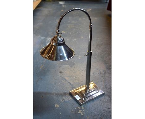 An electroplated desk lamp with conical shade and stepped base