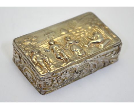 An Edwardian silver picture-top snuff box, the hinged cover embossed with rustic revellers, floral and foliate designs to the