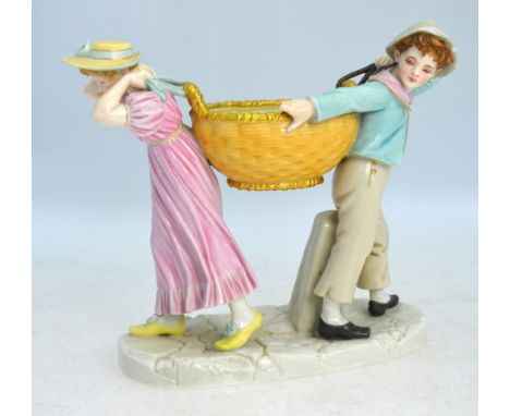 A Victorian Royal Worcester porcelain group of two children carrying a blush ground basket, raised on an oval rustic base, mo
