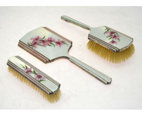 An Art Deco silver and enamel three-piece brush set, painted with pink orchids, Henry Clifford Davis, Birmingham 1938/39 Cond