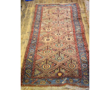 A Kurdish antique runner, the field of repeating lozenges on camel ground, 2.70 x 1.40 m Condition Report Good pile, some wea