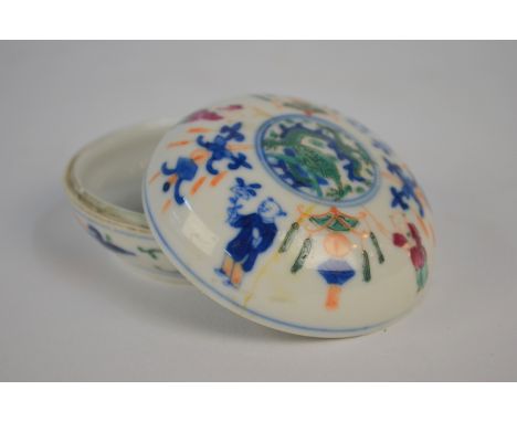 A famille rose and underglaze blue decorated circular box and cover; 6.5 cm diameter, the base with underglaze blue Qianlong 