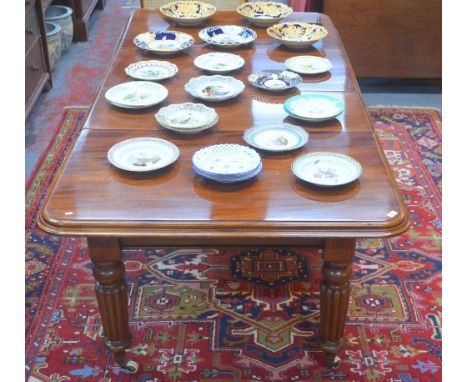 A Victorian mahogany extending dining table, the wind action accepting two insert leaves, raised on reeded turned legs on cer