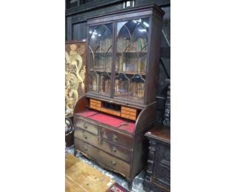 A George III mahogany cylinder top bureau bookcase, the astragal glazed doors over a satinwood fitted interior and slide out 