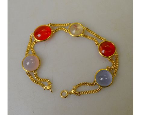 A two row yellow gold bracelet set with three pale blue cabochons and two fire opals and one water opal