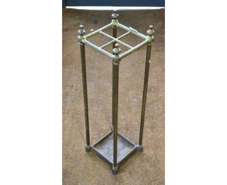 An antique brass and cast iron four-division stick stand with integral drip tray base