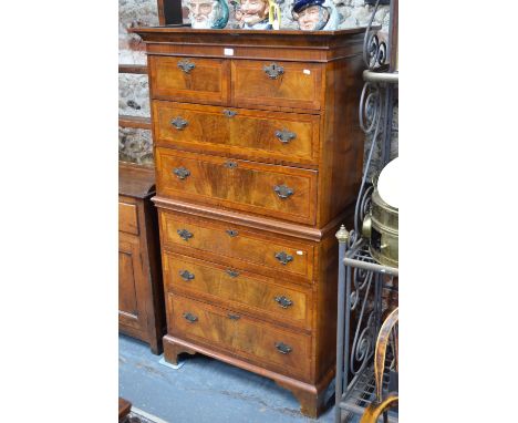 A small 19th century featherbanded walnut chest on chest, two short over five long graduated drawers, raised on shaped bracke