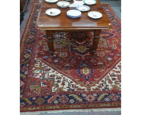 A Persian Heriz carpet, the traditional geometric centre medallion design on red/camel ground 3.35 m x 2.50 m