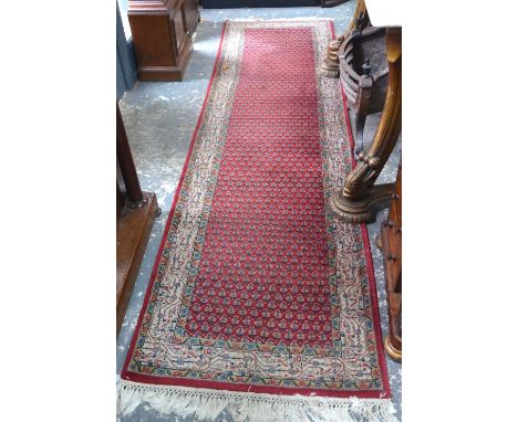 A Persian runner, the repeating boteh design on red ground within floral guarded beige border, 2.95 x 0.8 m