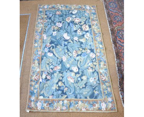 A classical needlepoint rug, the field of stylised flowers on green ground, 1.50 x 0.90 m