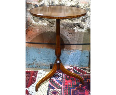 A Sheriton Revival satinwood tripod wine table, the circular top with lip edge and decorative band, raised on a conforming ba