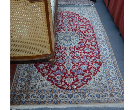 A Persian part silk Nian rug, the red ground centred by a centre flower medallion, 2.10 x 1.30 m