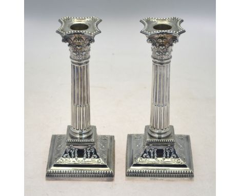 A late Victorian pair of loaded silver Corinthian column candlesticks on moulded square bases, James Dixon & Sons, Sheffield 