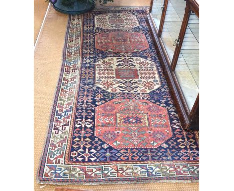 An antique Caucasian runner, the blue ground with four geometric panels, 2.50 m x 1.30 m Condition Report some areas of no pi
