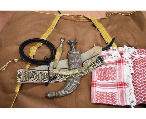 A Middle Eastern Omani Khunjar presentation dagger, with ornate white metal decoration, complete with scabbard, pus embroided