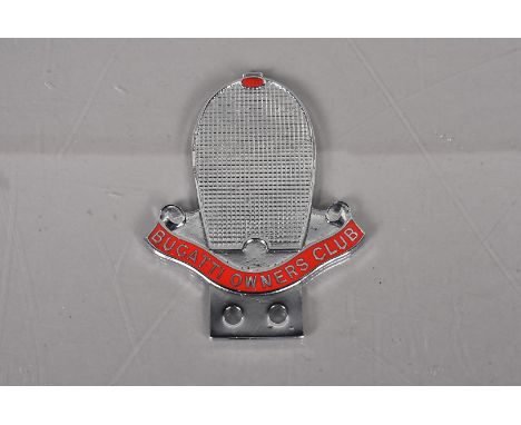 A Bugatti Owners Club chrome and enamel car badge, the badge in the form of a radiator grille, with applied red enamel scroll