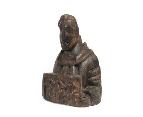 A Carved Oak Bust of a Saint, probably late 15th/early 16th century, holding a large plaque inscribed with a monogram, possib