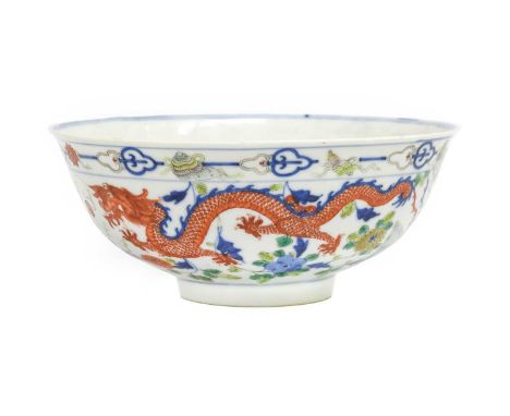 A Chinese Porcelain Bowl, 19th century, painted in wucai enamels with dragons and phoenix under a border of auspicious Buddhi