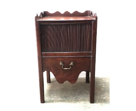 A George III mahogany tray top night commode, three quarter gallery with cutout handles, over a tambour front and pullout com