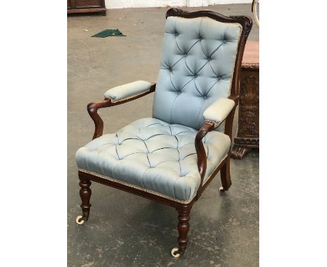A good quality mahogany and button upholstered open armchair, carved frame on baluster turned legs, brass caps and ceramic ca