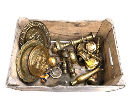 A vintage wooden crate containing a quantity of mixed metal and brass items, including candlesticks 