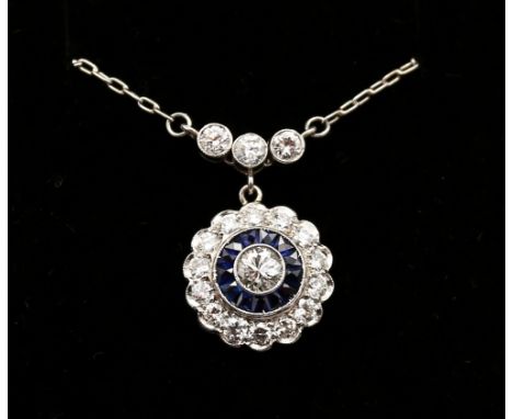 A sapphire and diamond platinum cluster pendant, comprising circular design set to the centre with a round brilliant cut diam