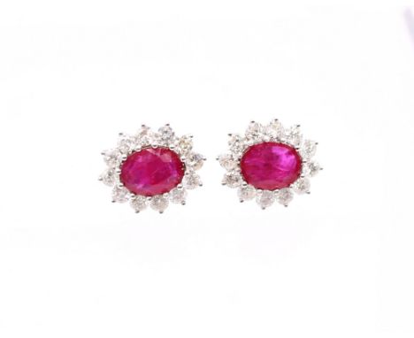 A pair of ruby and diamond set 18ct white gold oval cluster studs, rubies weighing a total of approx 3.15 carats, pinkish red