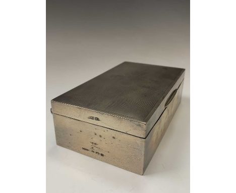 An engine-turned silver cigarette box