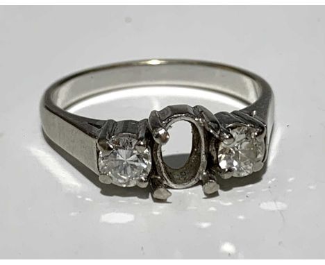 An 18ct white gold ring set with two diamonds but missing a central oval stone 5.2gm.Approx size: P1/2