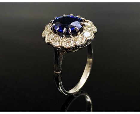 An impressive sapphire and diamond oval cluster platinum ring. The sapphire weight is calculated at 3.1ct The wonderfully bri