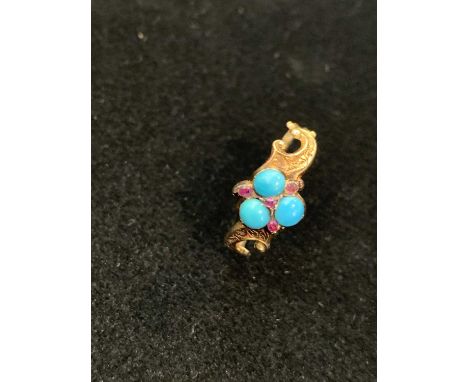 A very pretty Victorian gold mourning ring the shank with engraved scrolls, set with a turquoise trefoil and rubies, behind t