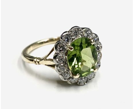 A peridot and diamond oval cluster ring.Approx size: N1/2-O leading edge