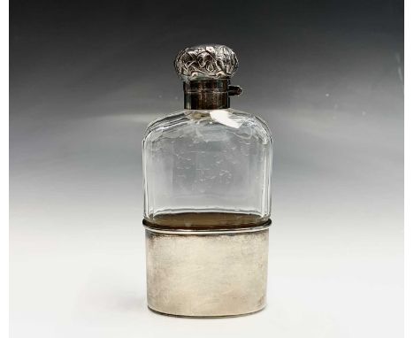 An Edwardian cut glass flask with silver cup base and embossed Art Neaveau iris decorated silver bayonet lid London 1906