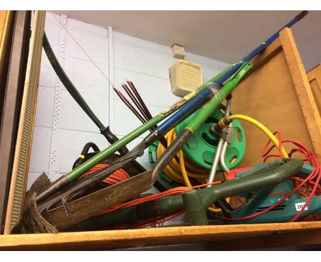 A shelf of gardening tools, including hose etc.