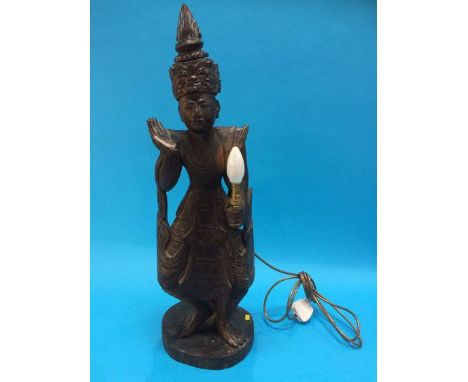 A carved Indonesian figural lamp
