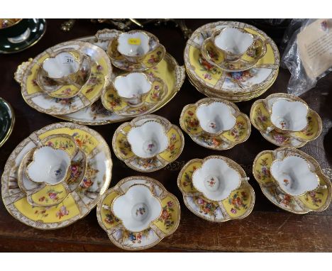 A collection of Dresden cabinet cups, saucers, plates and a tray, decorated with alternate panels of flowers to a yellow grou