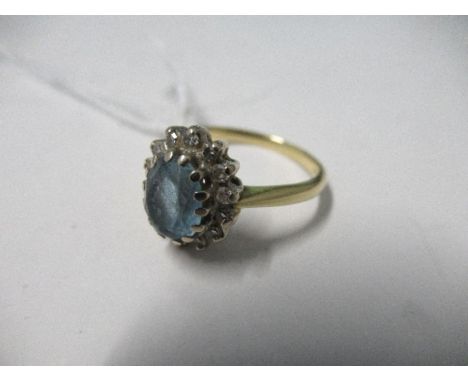 A cluster ring, stamped '18ct', the oval cut blue stone enclosed by single cut diamonds, finger size L, 3.8g gross