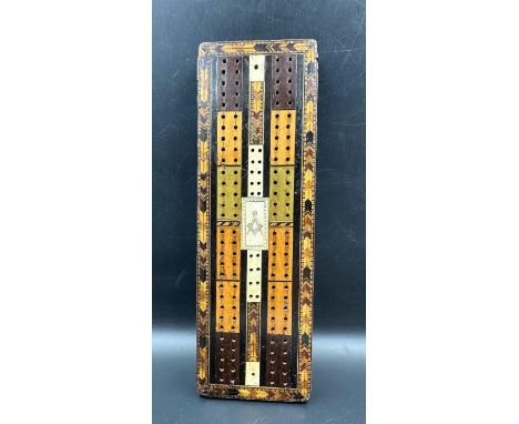 A very interesting Victorian cribbage board made of Various woods with the Masonic set Square and compass symbol to centre. A