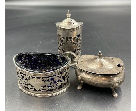 Three silver cruets with blue glass liners, various hallmarks and makers.