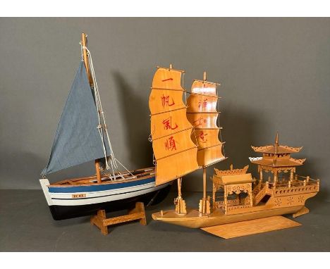 Two wooden scale model boats, a Chinese Junk boat and a small sailing Vessel on stand