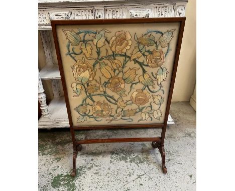 A mahogany framed fire screen on splayed feet with floral tapestry insert 