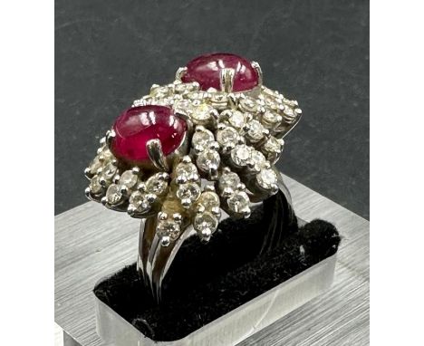 A diamond and ruby cluster ring on 18ct, marked 750 white gold with two central stones and multiple diamonds.