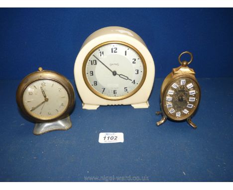 A cream Smiths Bakelite clock, H.A.C brass clock and small oval brass clock.
