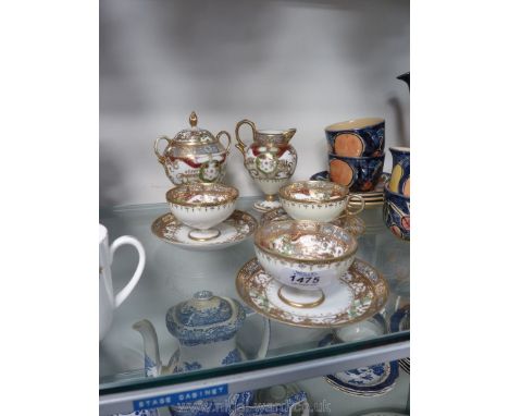 A Noritake part cabinet tea service with ornate decoration, three cups and saucers, milk jug and sucrier.