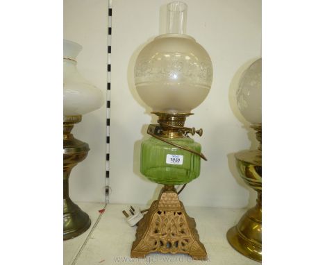 An oil lamp converted to electric with metal base, light green reservoir, globe shape shade with clear chimney, 23" tall.