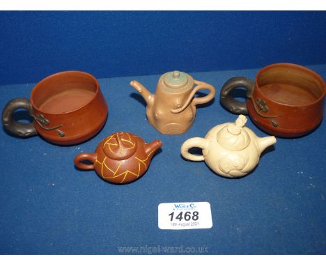 A small quantity of terracotta and light clay pieces including three miniature teapots and two cups.